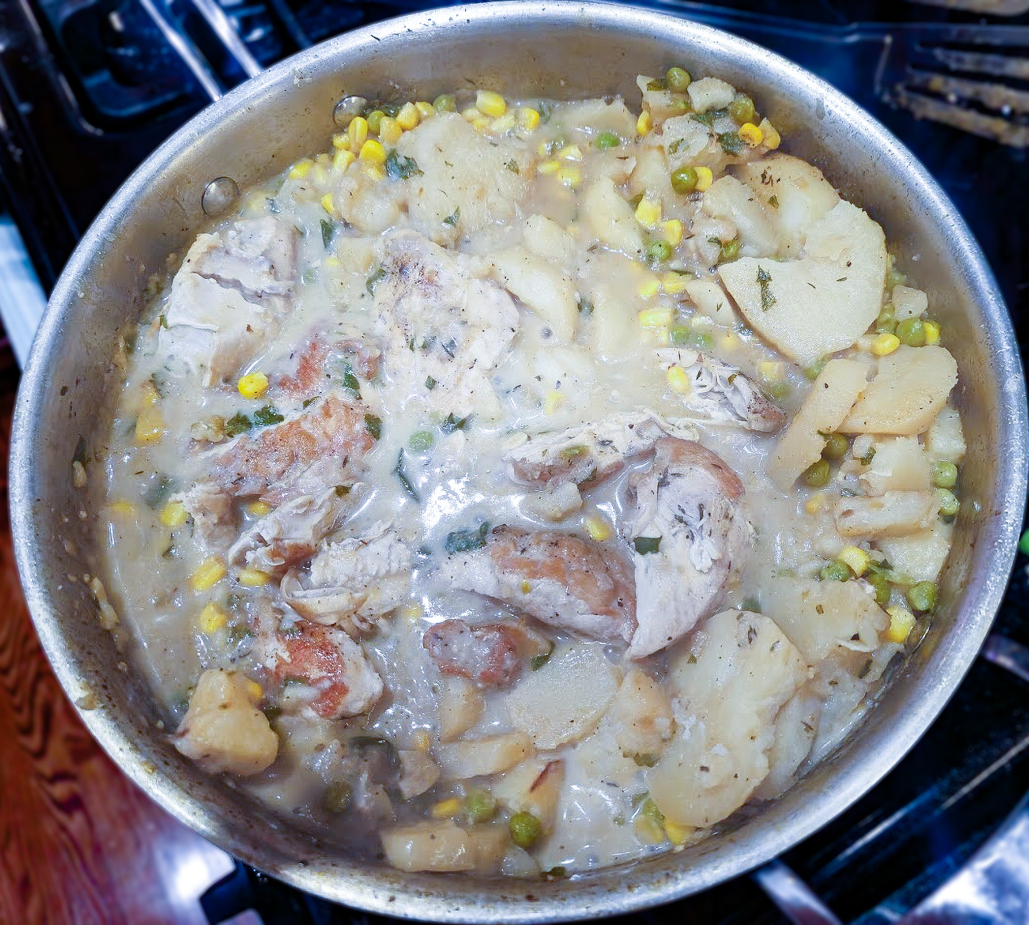 One-pan creamy chicken and potato skillet with corn and peas, simmering in a bone broth and Fairlife milk sauce.